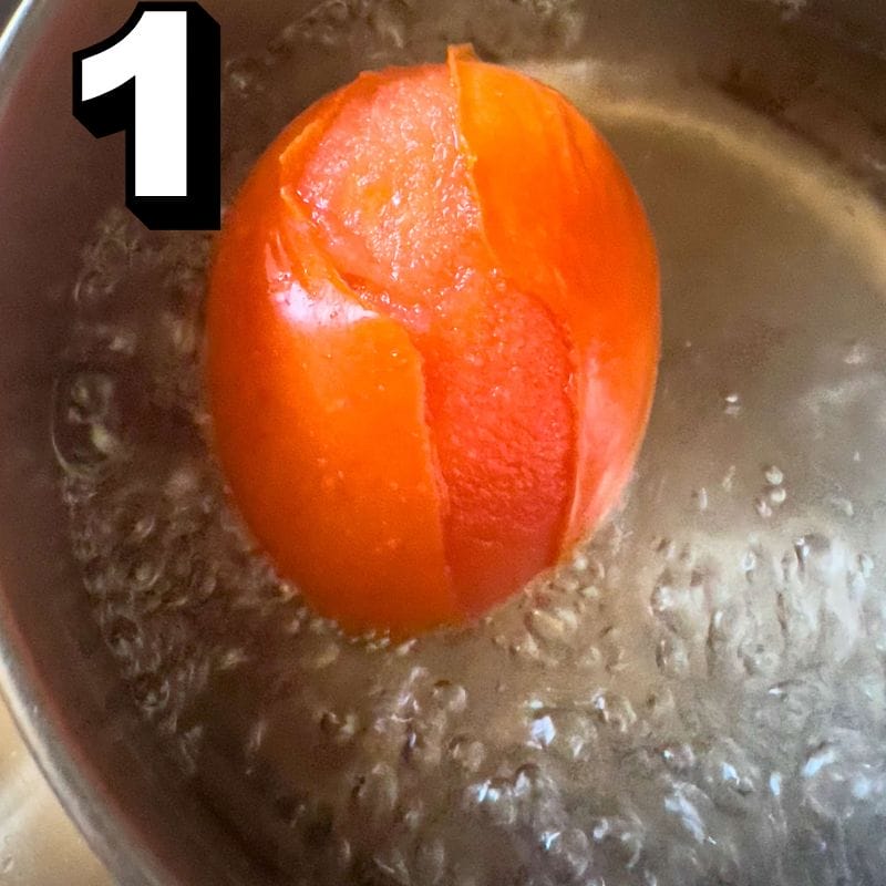 Boil tomato in a cup of water.